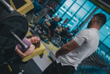 Sesión de entrenamiento en el gimnasio con un entrenador personal, enfocada en el rendimiento y el bienestar físico.